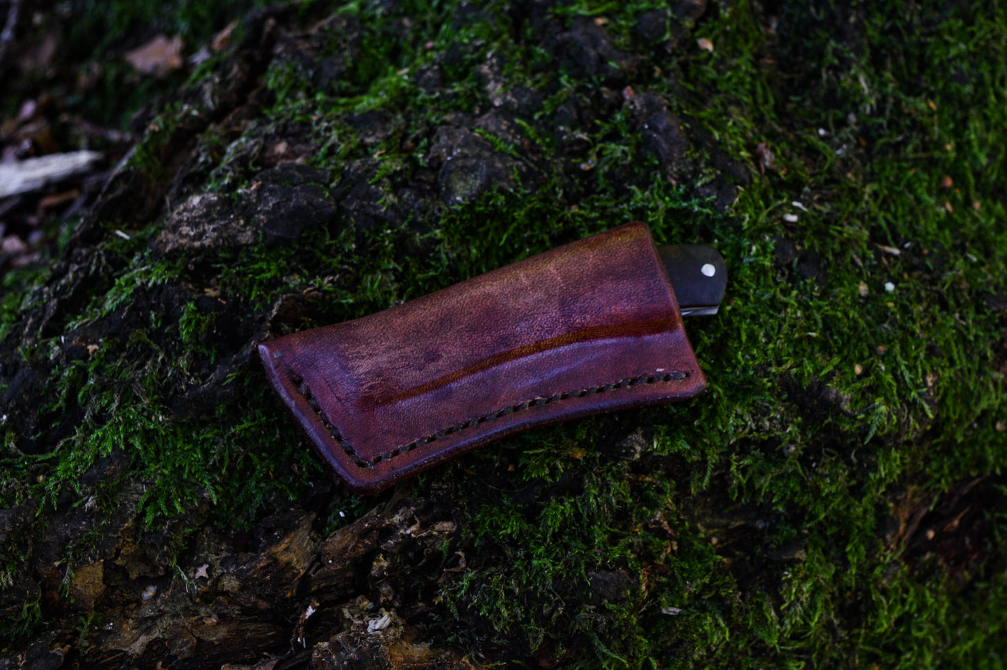 Hand-forged slipjoint folding knife with a pattern-welded blade. Wrought Iron Bolsters with Black Ash Burl Scales. Non-locking UK Legal Carry