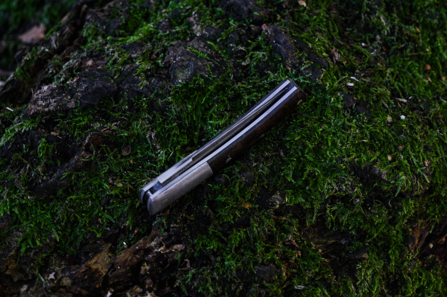 Hand-forged slipjoint folding knife with a pattern-welded blade. Wrought Iron Bolsters with Black Ash Burl Scales. Non-locking UK Legal Carry